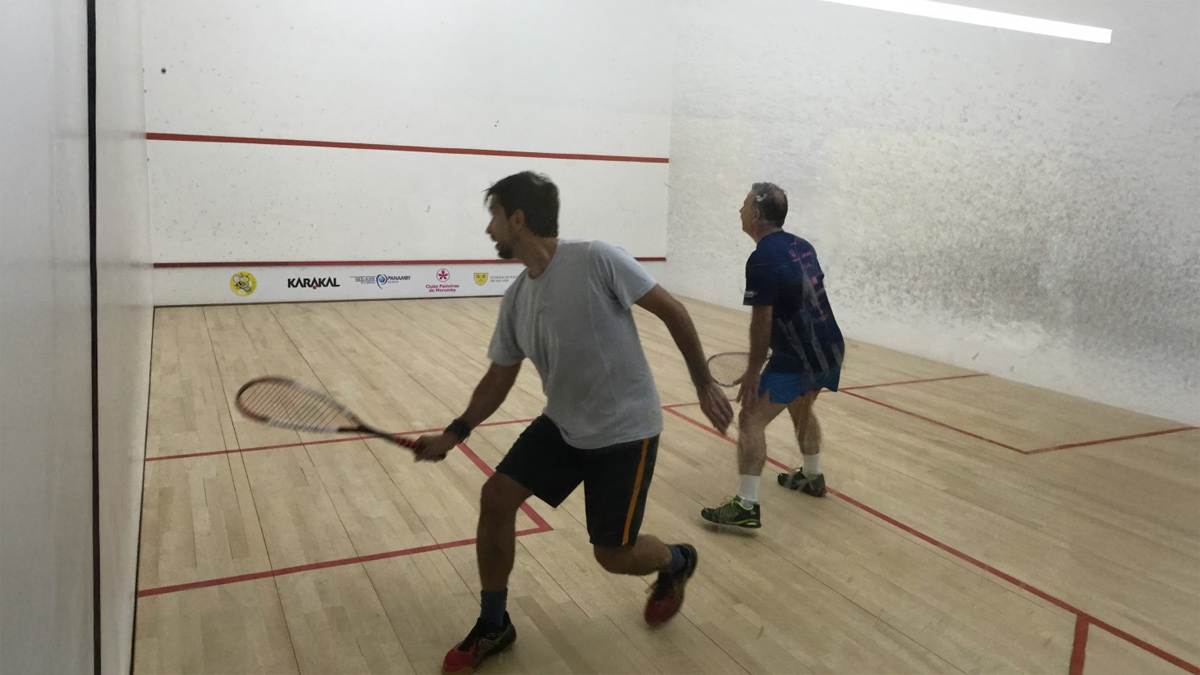 Jogadores disputando uma partida de squash em quadra indoor no Clube Paineiras do Morumby