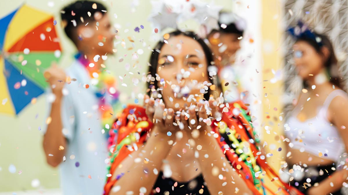 Foliã assoprando confetes no carnaval