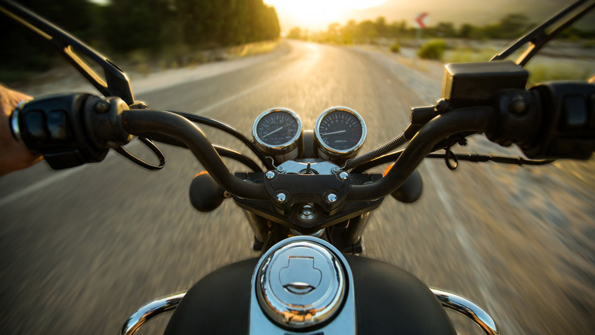Visão em primeira pessoa de um motocilista pilotando a sua moto na estrada