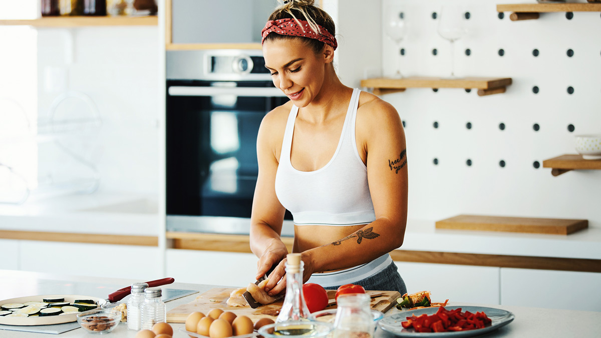 Mulher na cozinha preparando sua comida da dieta