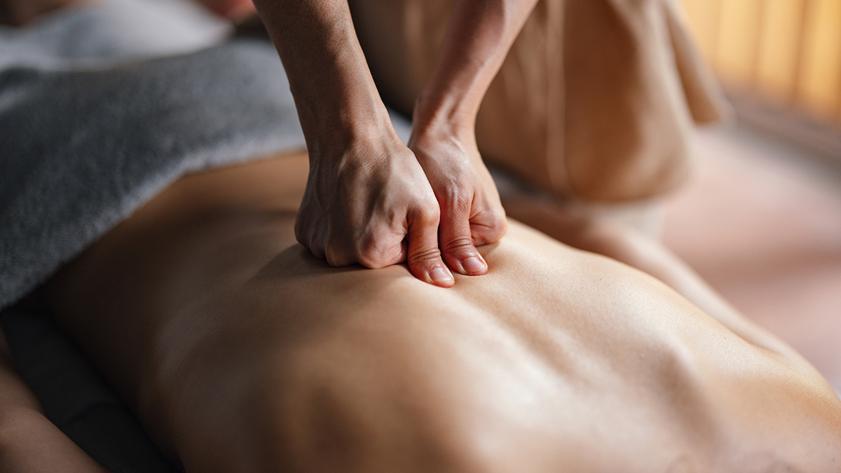 Foto close up de massagista fazendo massagem nas costas de uma mulher