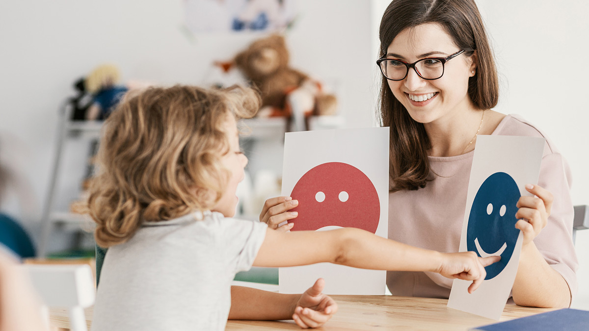 Mãe a segurar dois papéis, e sua filha a apontar para uma deles.