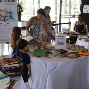 Na imagem, família de associados que estava escolhendo seus livros no Sebo Social.