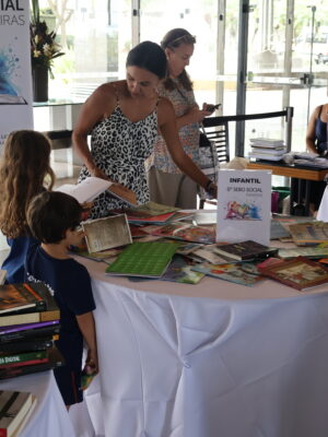 Na imagem, família de associados que estava escolhendo seus livros no Sebo Social.
