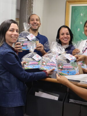 Na imagem, setor do RH entregando os livros de colorir para outros colaboradores do Paineiras.