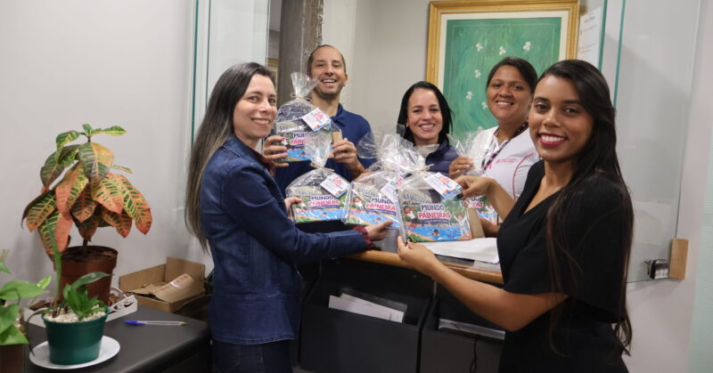 Na imagem, setor do RH entregando os livros de colorir para outros colaboradores do Paineiras.